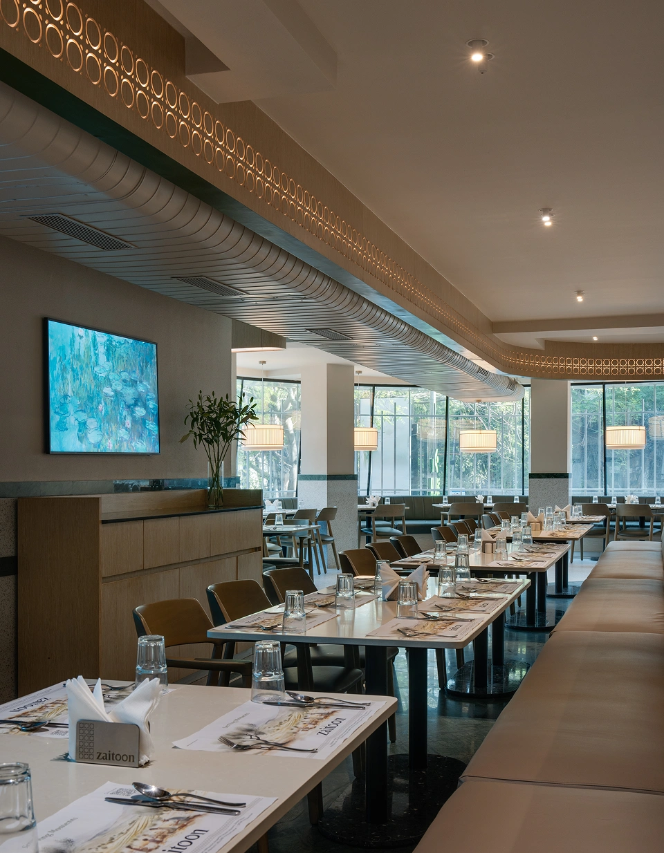 Rows of table settings beside floor-to-ceiling windows in the main dining area